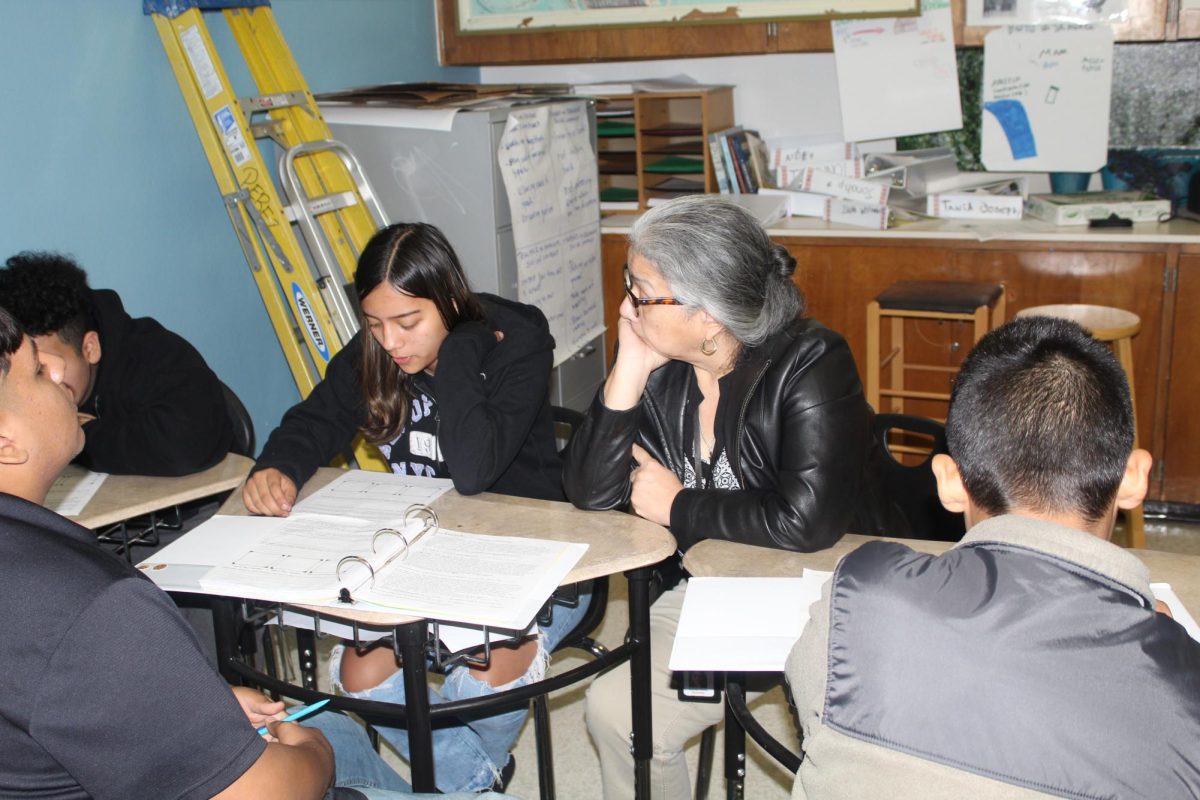 Dr. Perez helping an 8th grade student, Daniela Barrera, with her work.